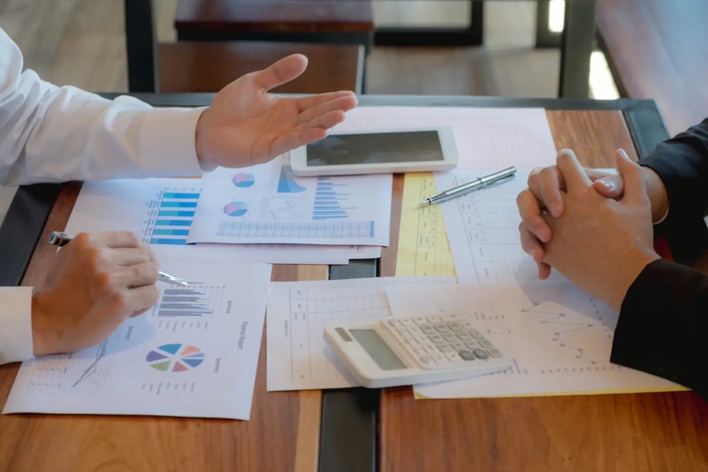 Financial advisor explaining charts and projections during a retirement planning meeting, reviewing income strategies, investment allocation, and long-term wealth management decisions.