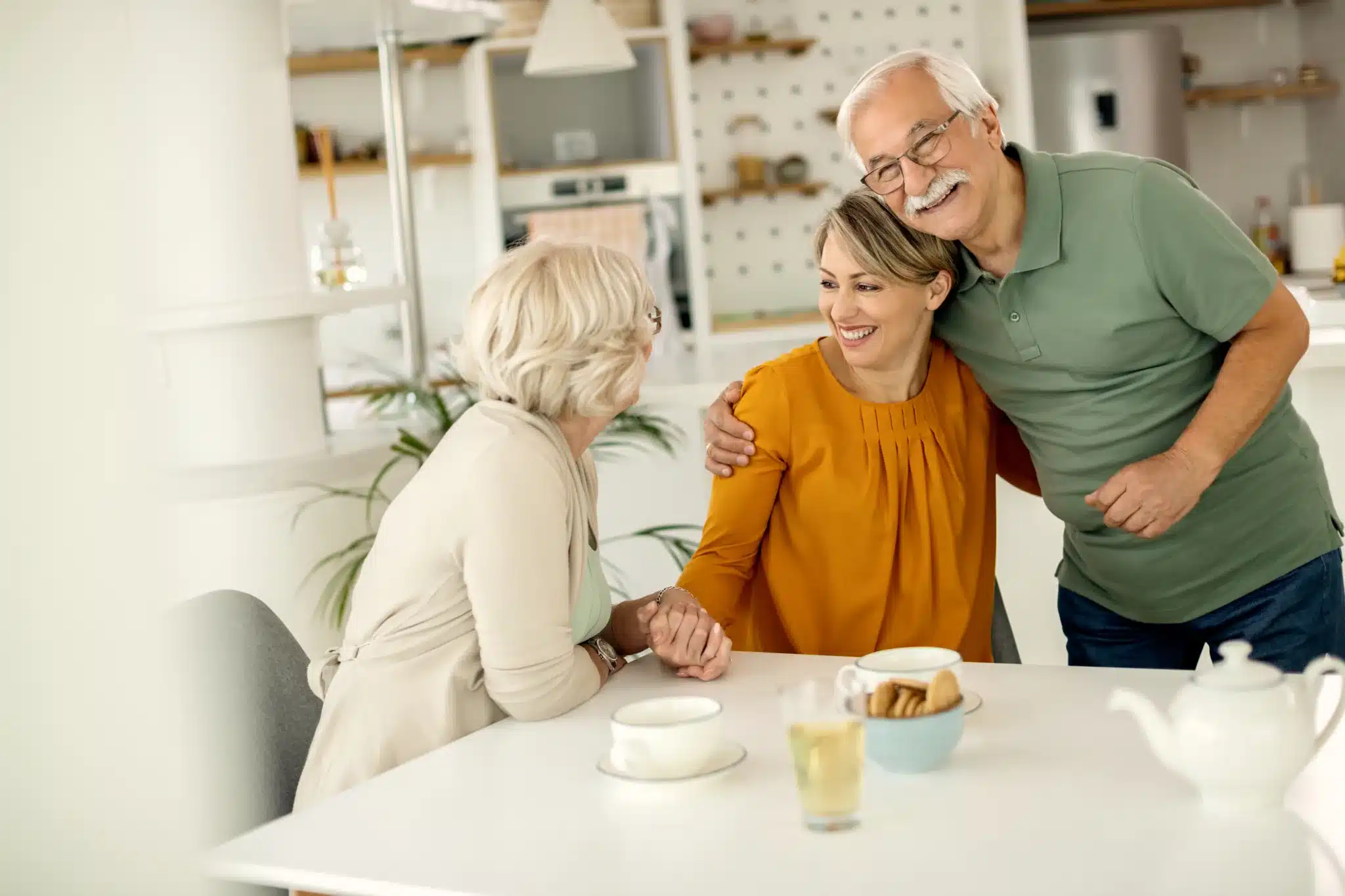 Older parents talking with their adult daughter at home.