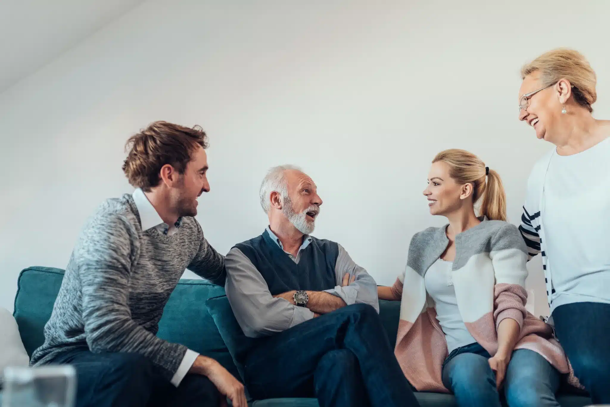 Adult children talking with their older parents in a living room.